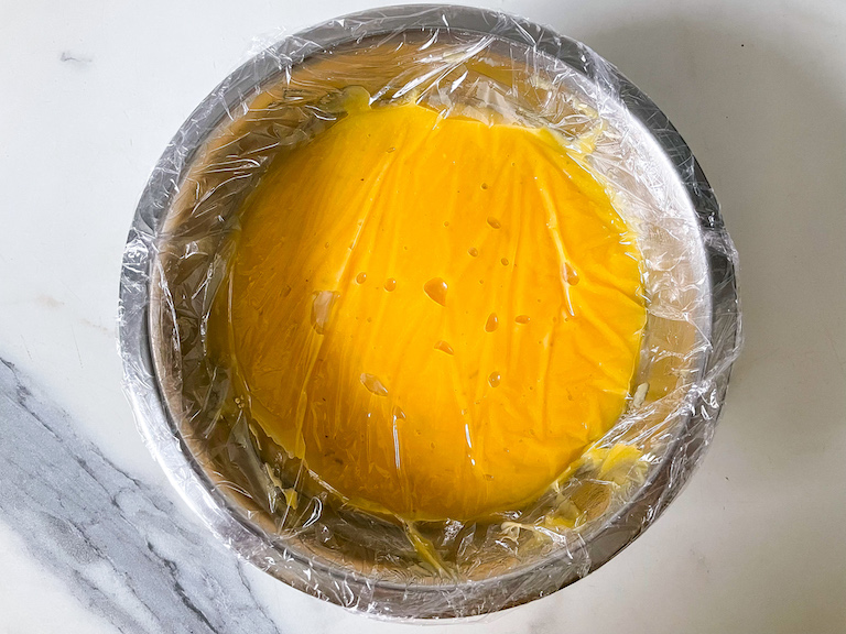 Lime curd in a bowl covered in plastic wrap