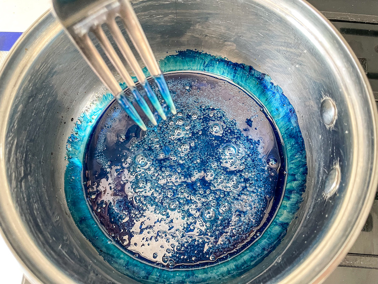 A pot of blue sugar syrup and a fork