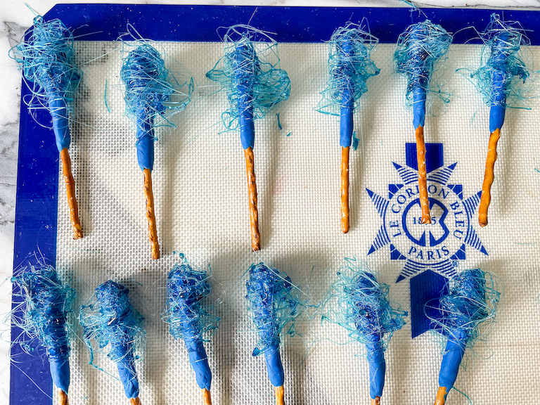 Blue spun sugar sparklers on a silicone mat
