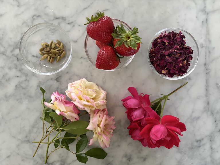 Ingredients for making a rose simmer pot (stovetop potpourri) arranged on a marble surface