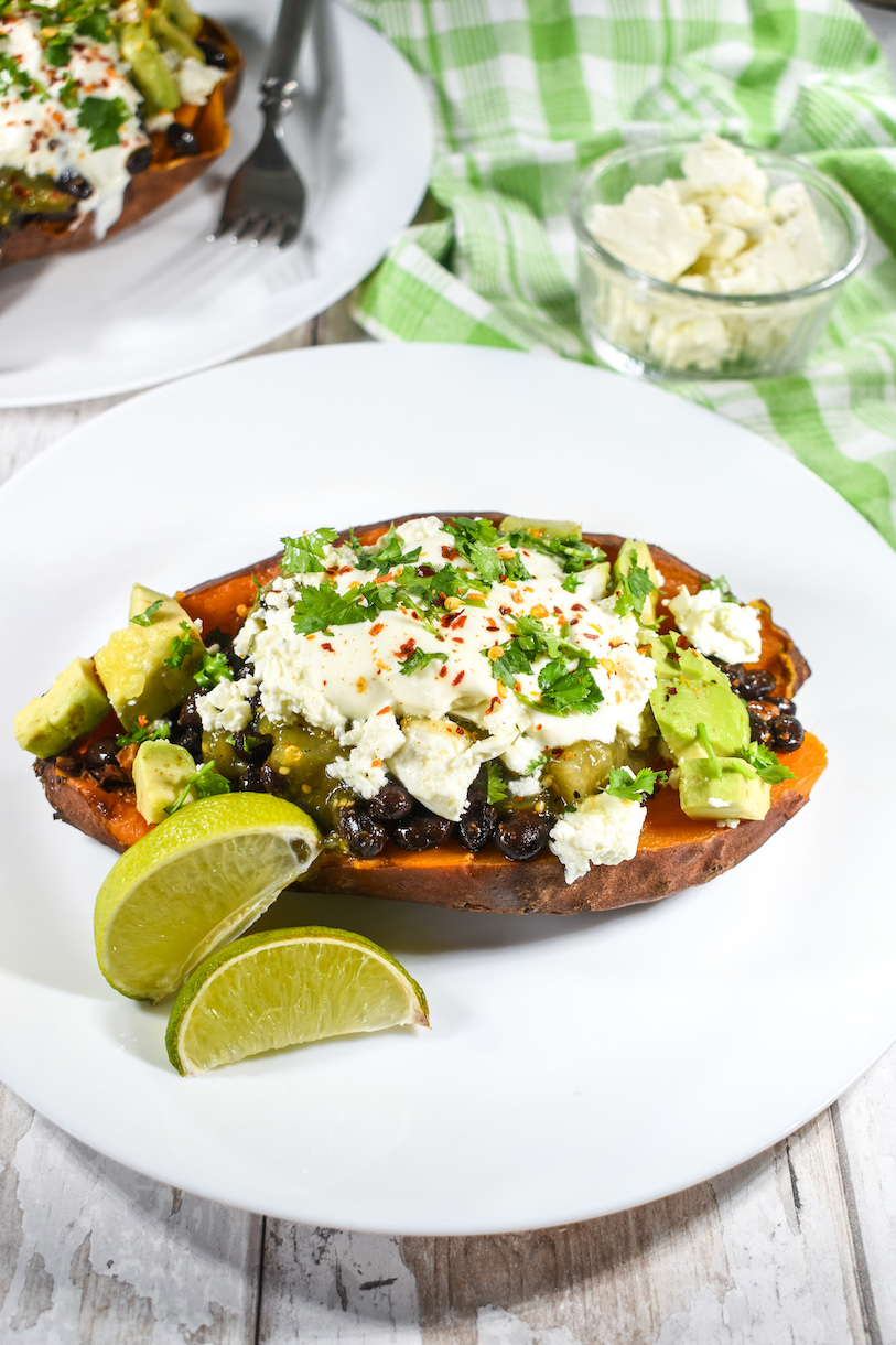 Taco sweet potato with lime wedges on white plate