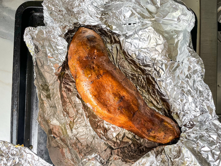 A baked sweet potato on a sheet of foil