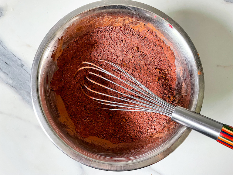 Whisk in a bowl with chocolate cake ingredients