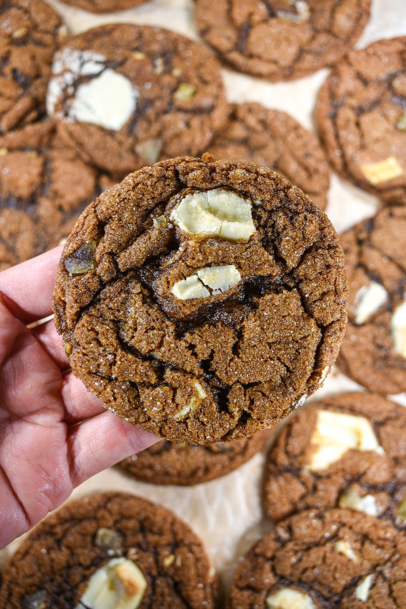 Hand holding a bakery style chai chocolate chip cookie