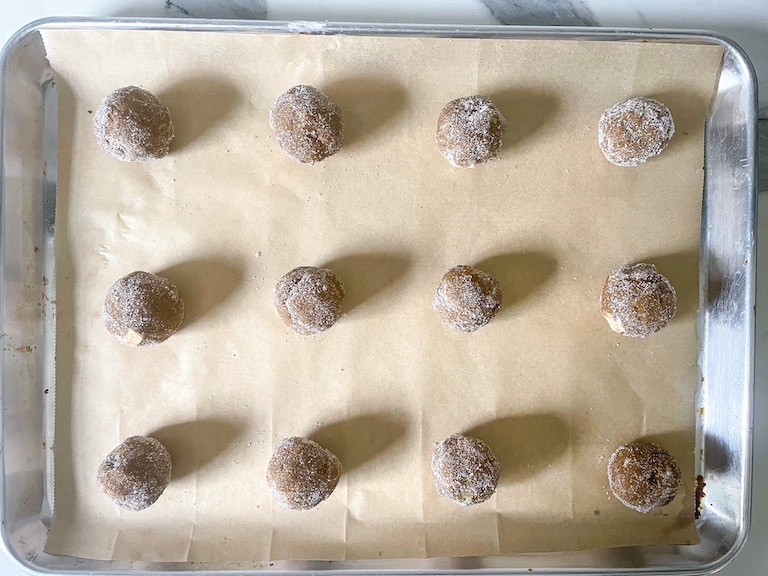 balls of cookie dough arranged on a parchment lined tray