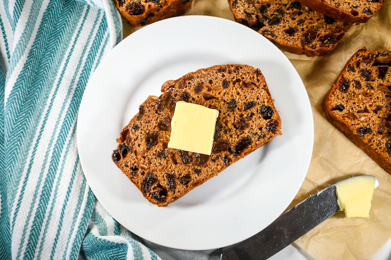 A slice of bara brith on a white plate