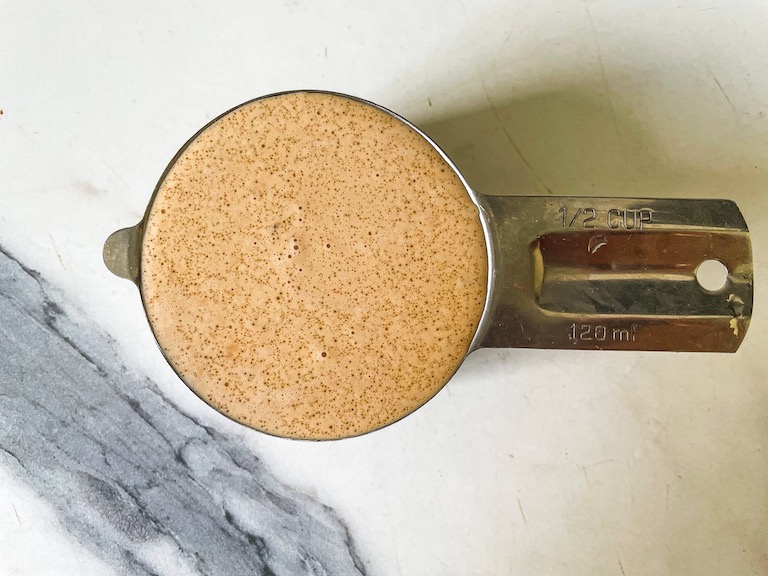 A measuring cup of chai infused cream