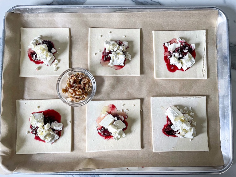 Tray with puff pastry, cherry compote, feta, and dish of walnuts