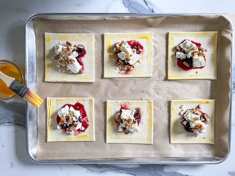 Squares of puff pastry with cherries and feta