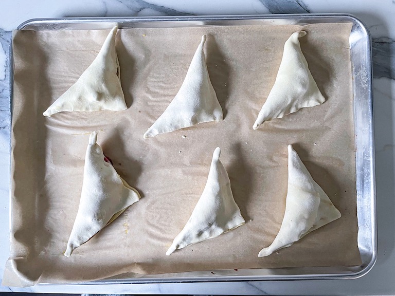 Triangles of puff pastry on a tray