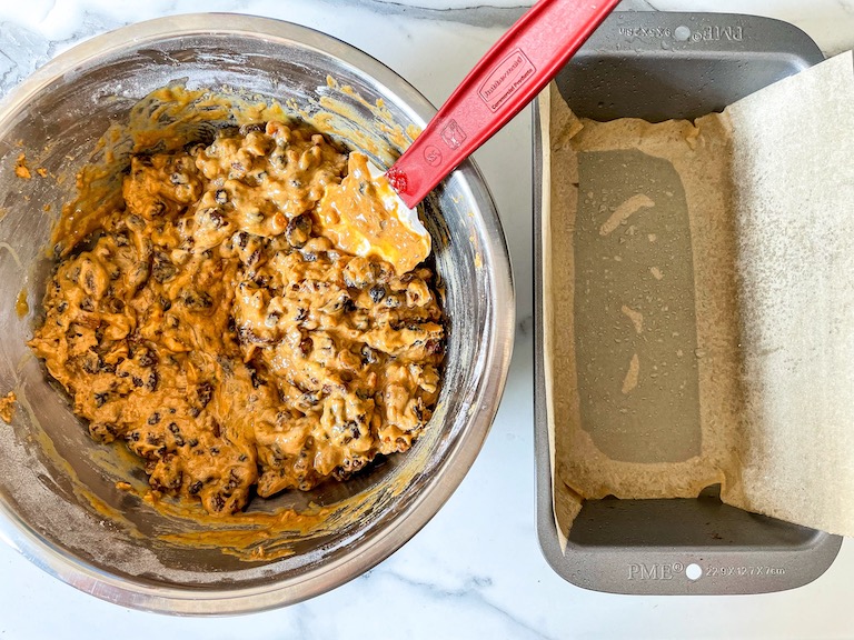 A bowl of bara brith batter next to a loaf tin