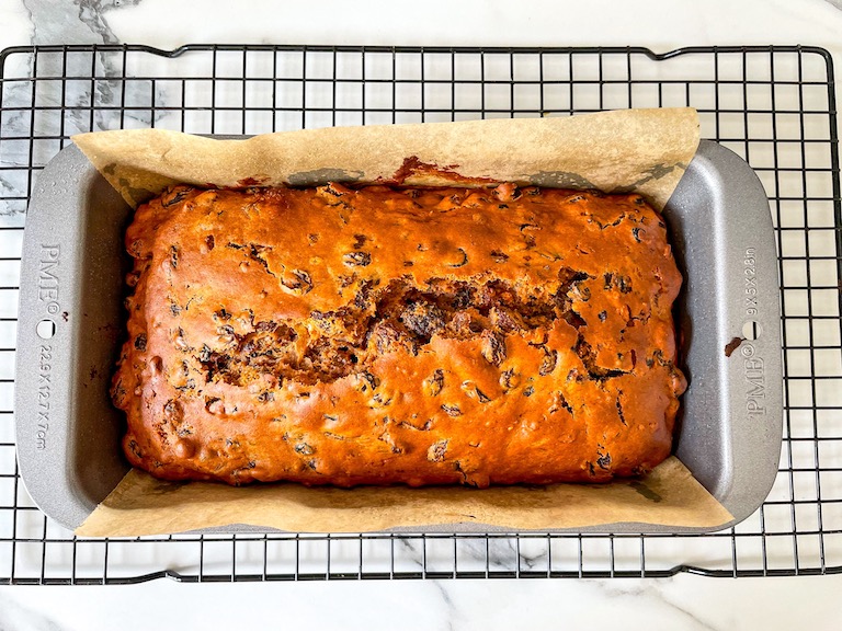 A loaf of Welsh bara brith bread cooling on a wire rack