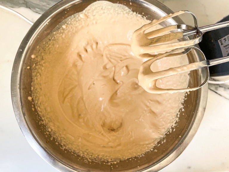 A hand mixer mixing coffee whipped cream