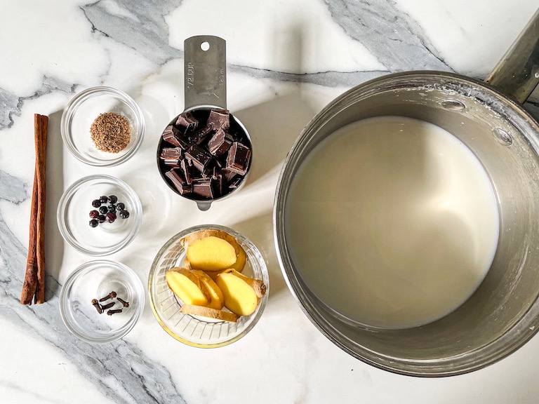 Dishes with ingredients for making a gingerbread hot chocolate recipe