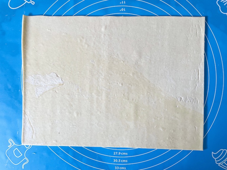 Sheet of puff pastry on a rolling mat