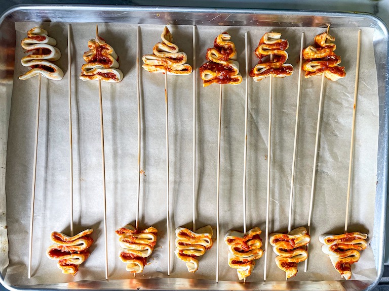 Unbaked puff pastry Christmas trees on a tray