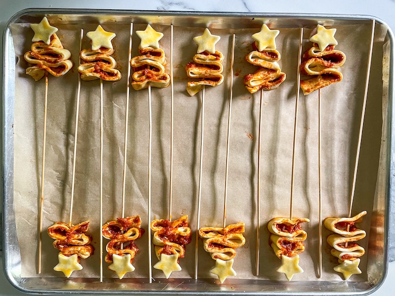 Puff pastry Christmas trees arranged on a parchment lined tray