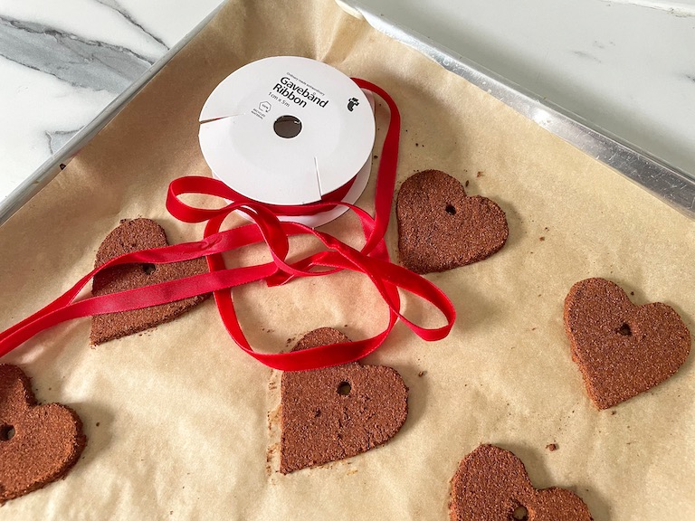 Cinnamon ornaments on a tray with a spool of red ribbon