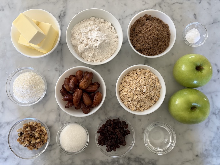 Ingredients for making apple date bars arranged on a marble surface