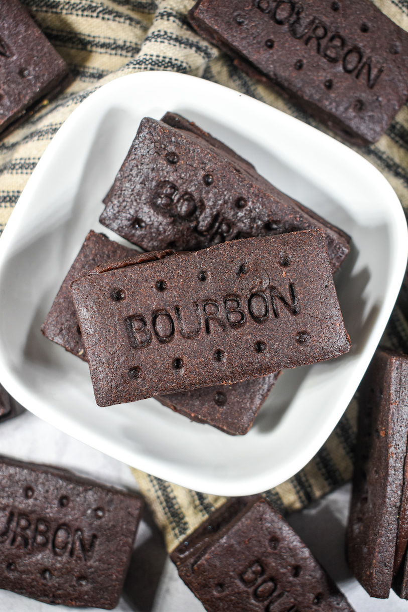 A small white bowl with a stack of bourbon cream biscuits