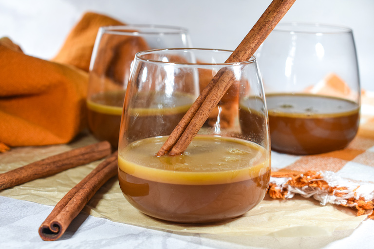 Glasses of hot buttered brandy with cinnamon sticks