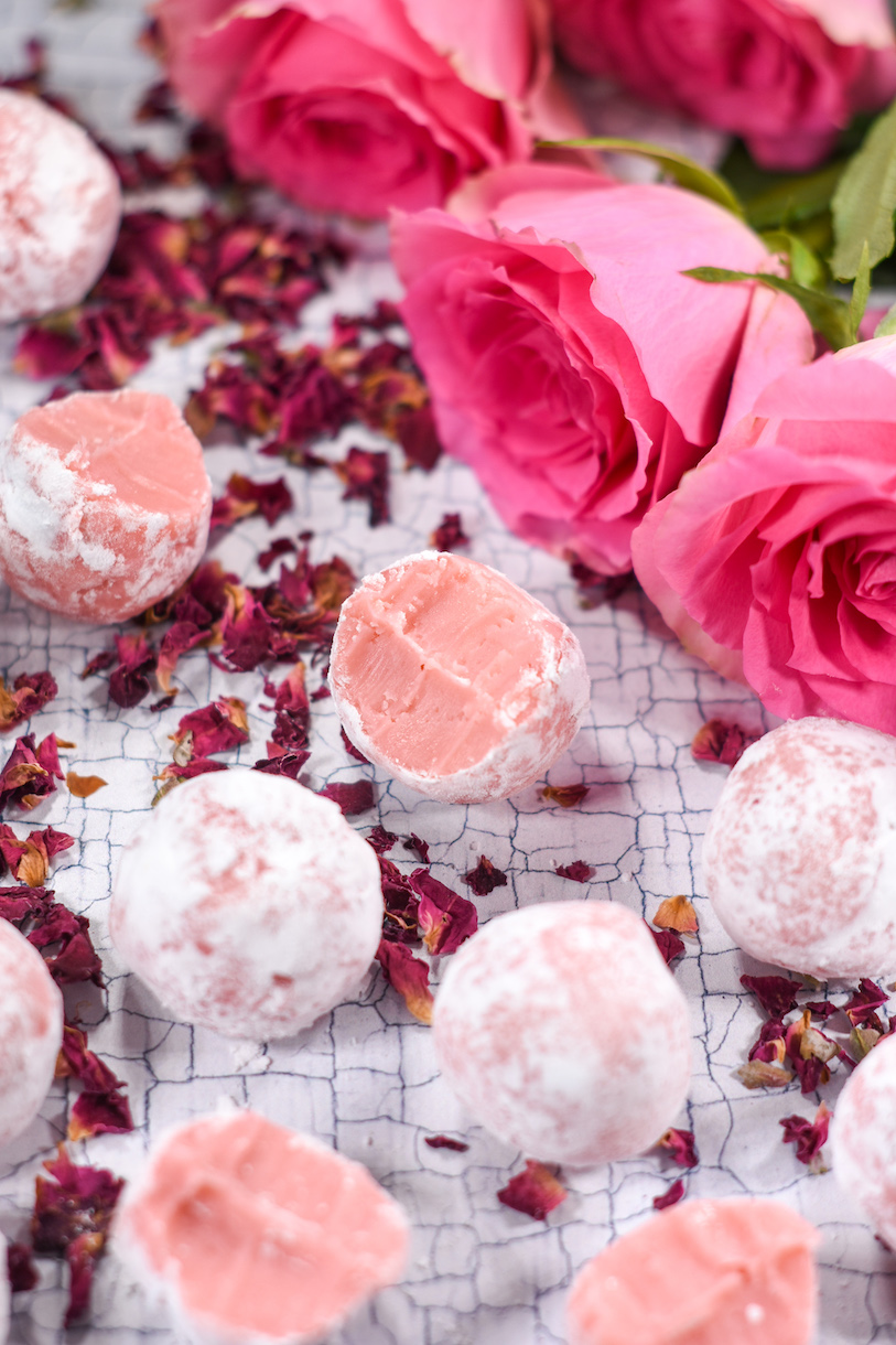 A half eaten rose truffle and a bouquet of pink roses