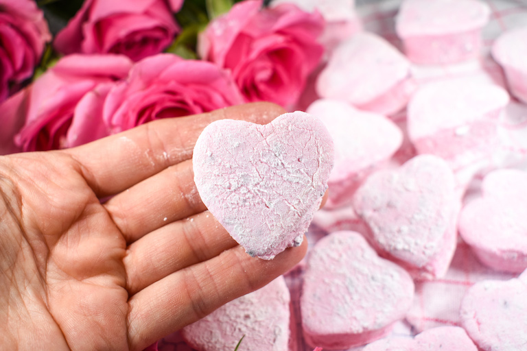 Hand holding a rose marshmallow shaped like a heart