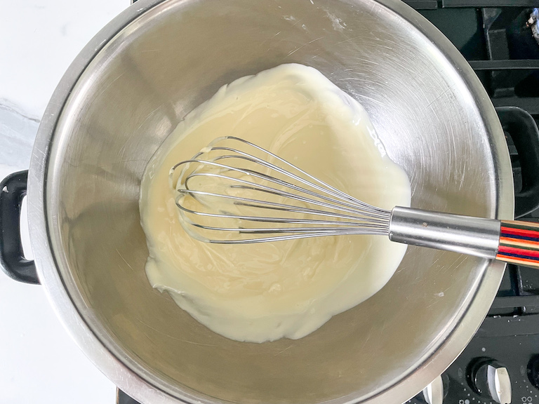 Melted white chocolate and a whisk