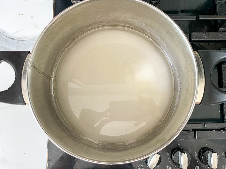 Bowl of sugar and water on a stovetop