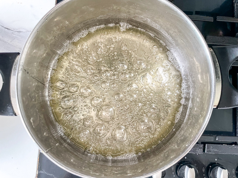 Sugar and corn syrup boiling in a pot on the stovetop