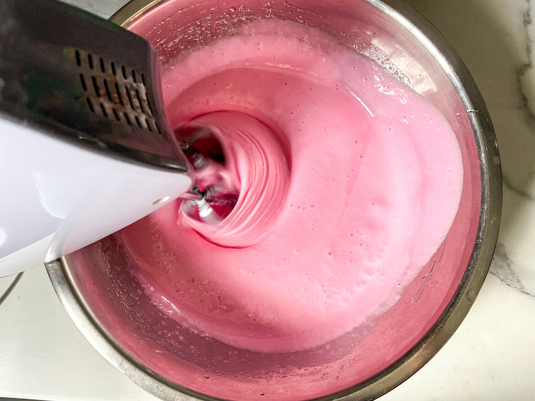 Mixing pink marshmallow fluff in a bowl