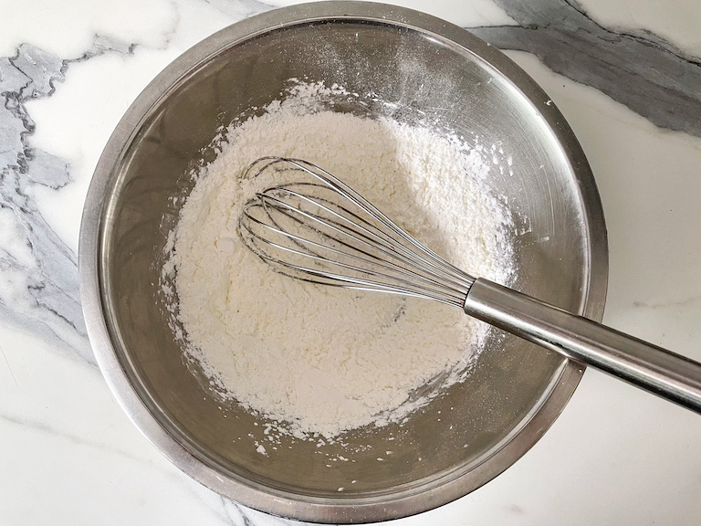 Cornflour and confectioner's sugar in a bowl with a whisk