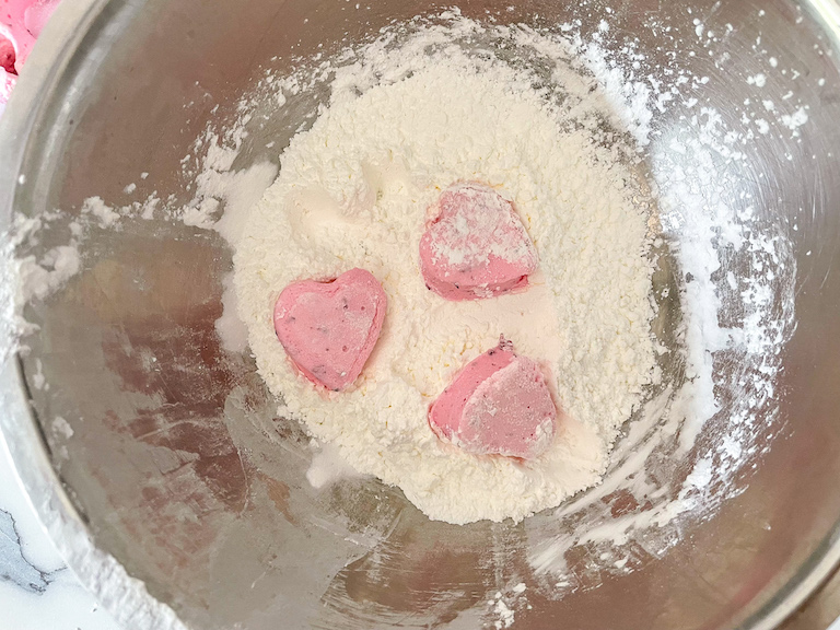 Pink heart marshmallows in a bowl of cornflour