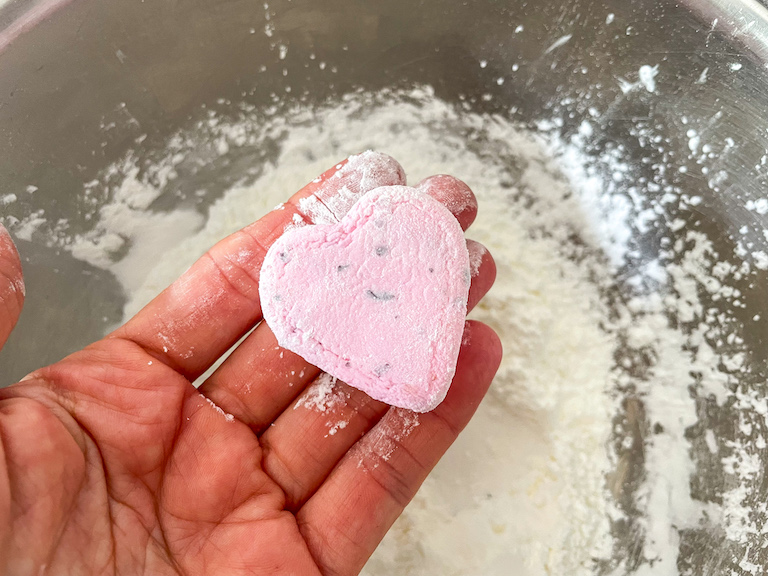 Hand holding a pink marshmallow