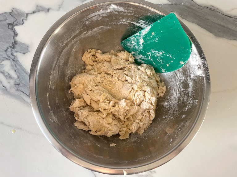 Bread dough and scraper in a bowl