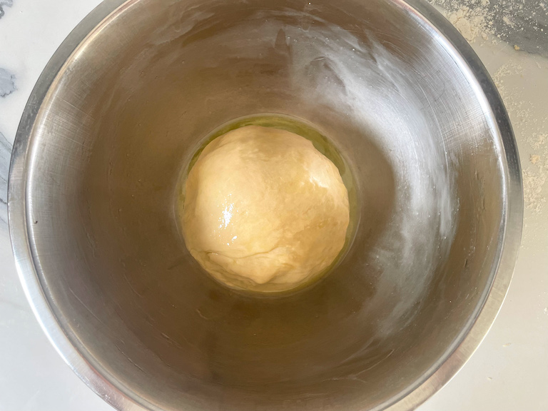 A ball of dough in a bowl with olive oil