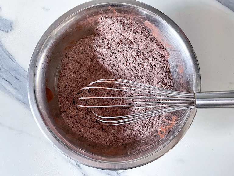 A bowl of cocoa powder with a whisk