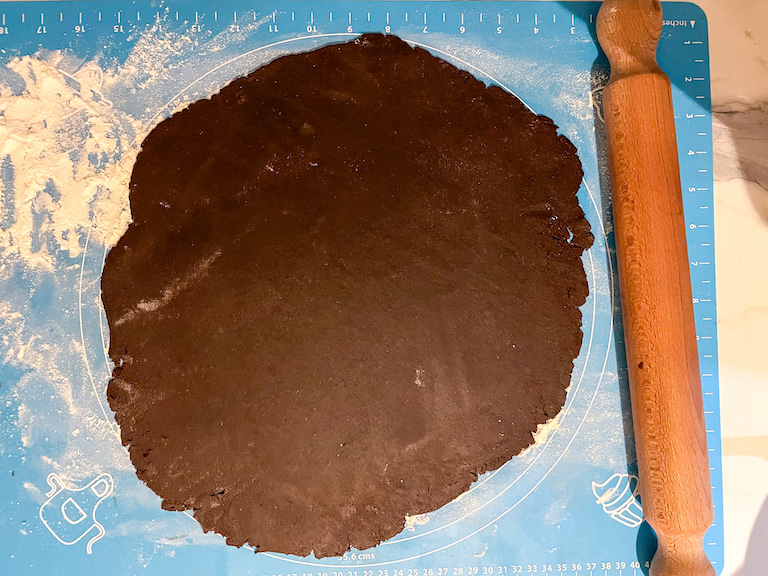 Chocolate bourbon biscuit dough on a rolling mat