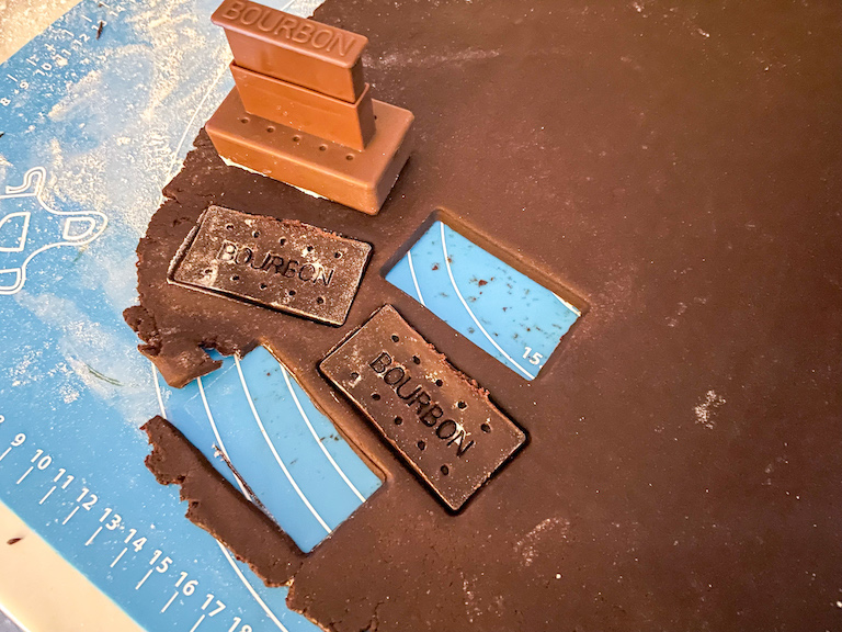 Cutter cutting chocolate dough to make homemade bourbon biscuits