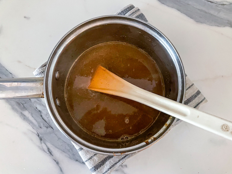 A pan with hot buttered brandy and a spoon