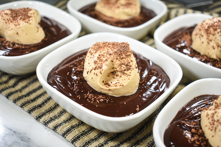 Dishes of chocolate pudding with coffee whipped cream