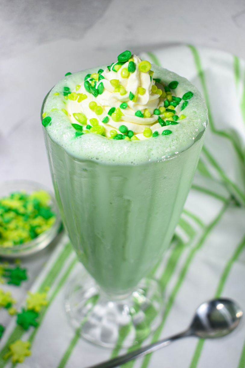 peppermint milkshake in a milkshake glass with whipped cream and sprinkles