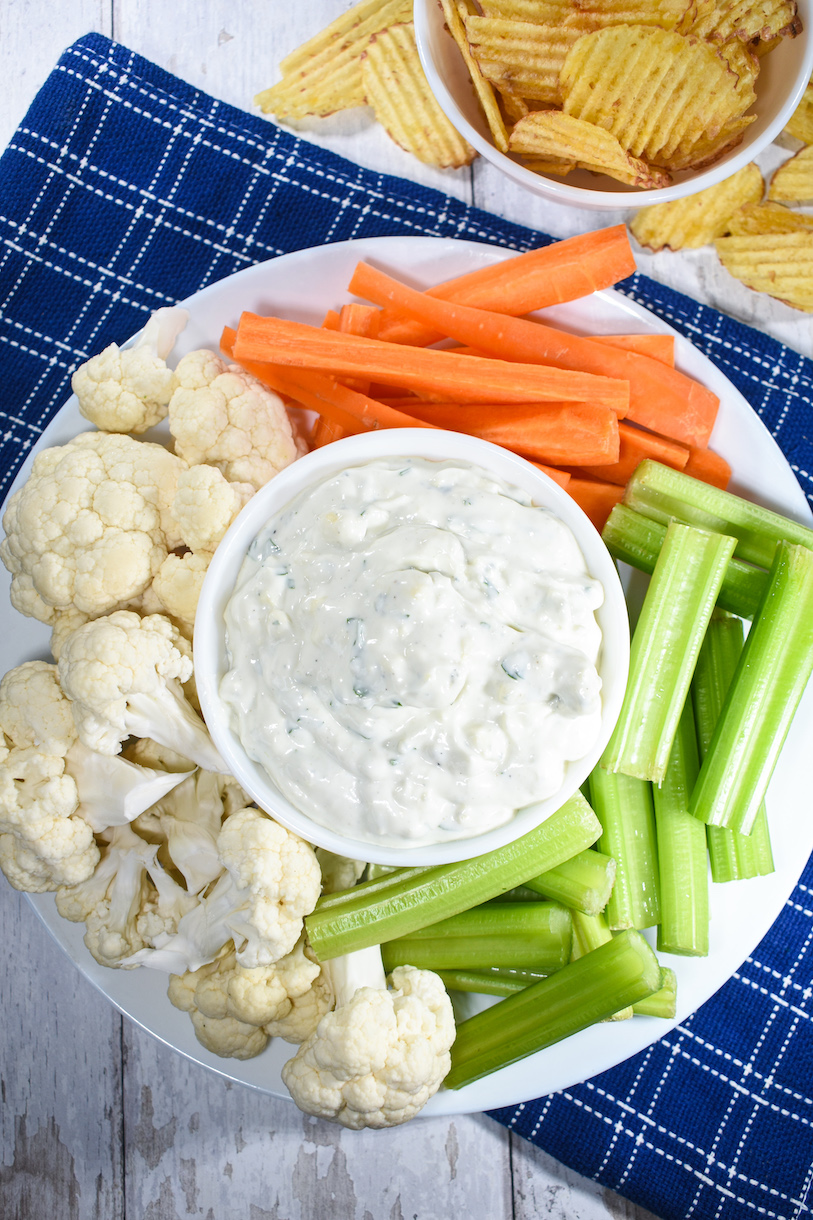 a dish of blue cheese dip surrounded by raw vegetables