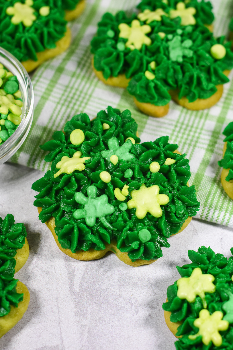 a shamrock sugar cookie on a plaid green towel