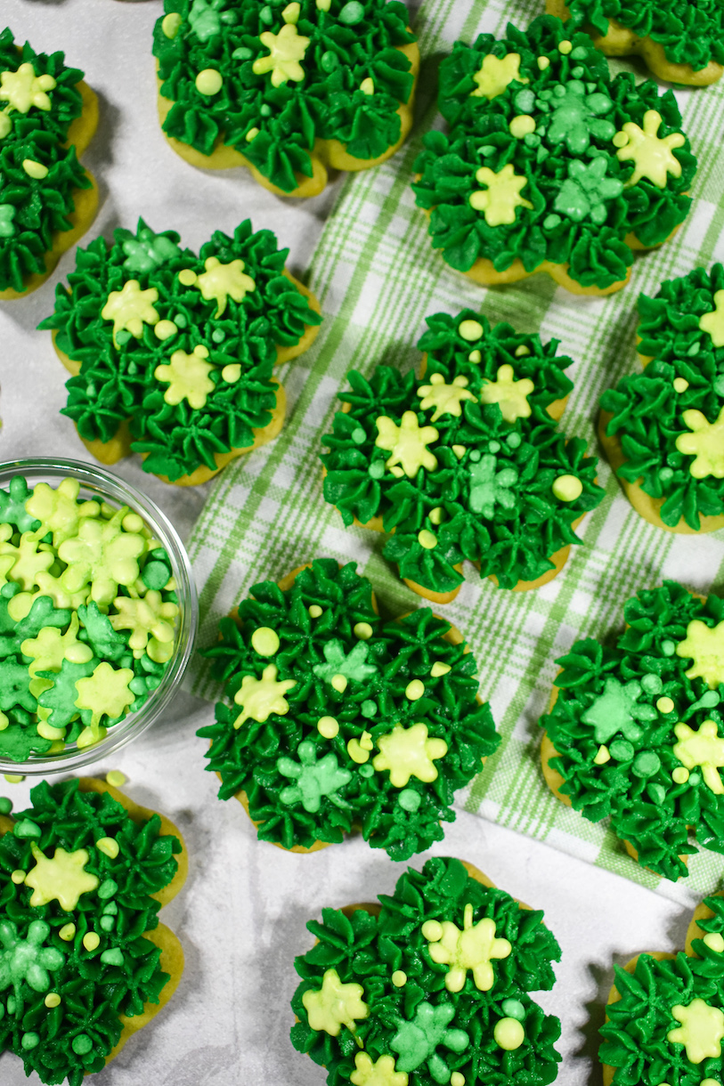 Green shamrock shaped sugar cookies on a green plaid towel