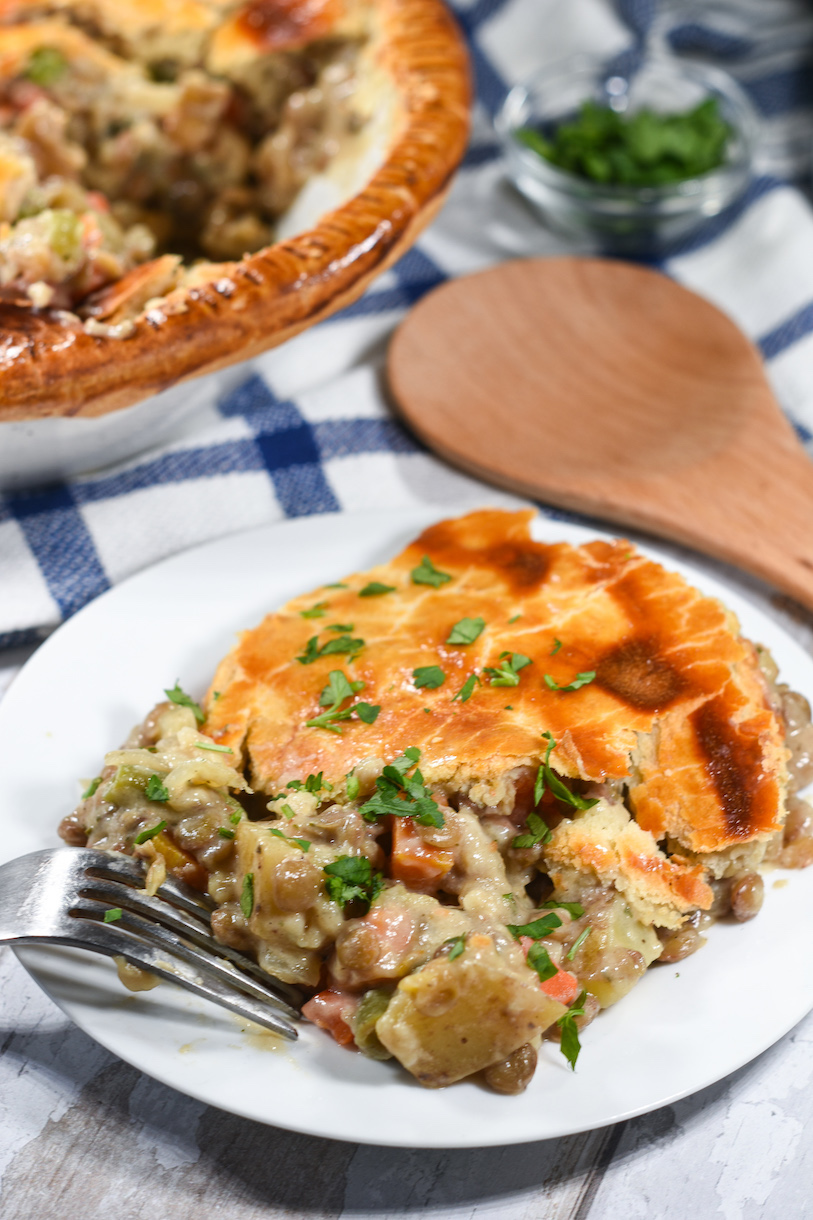 A slice of lentil pot pie on a white plate