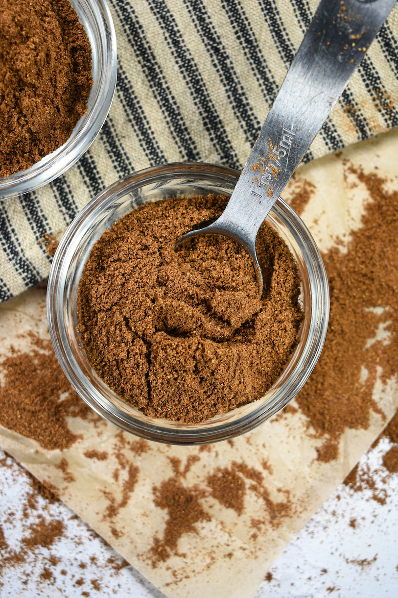 Dish of homemade British mixed spice with a spoon