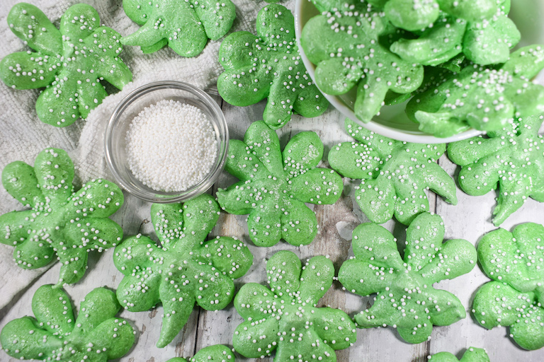 Green shamrock cookies on a white surface