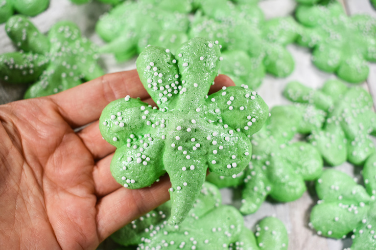 Hand displaying St. Patrick's Day meringue cookies