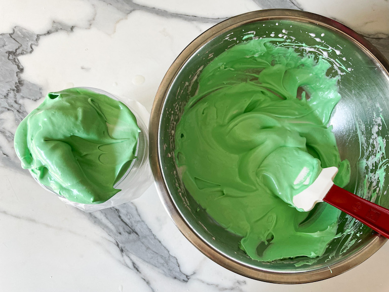 Green meringue in a bowl and a piping bag